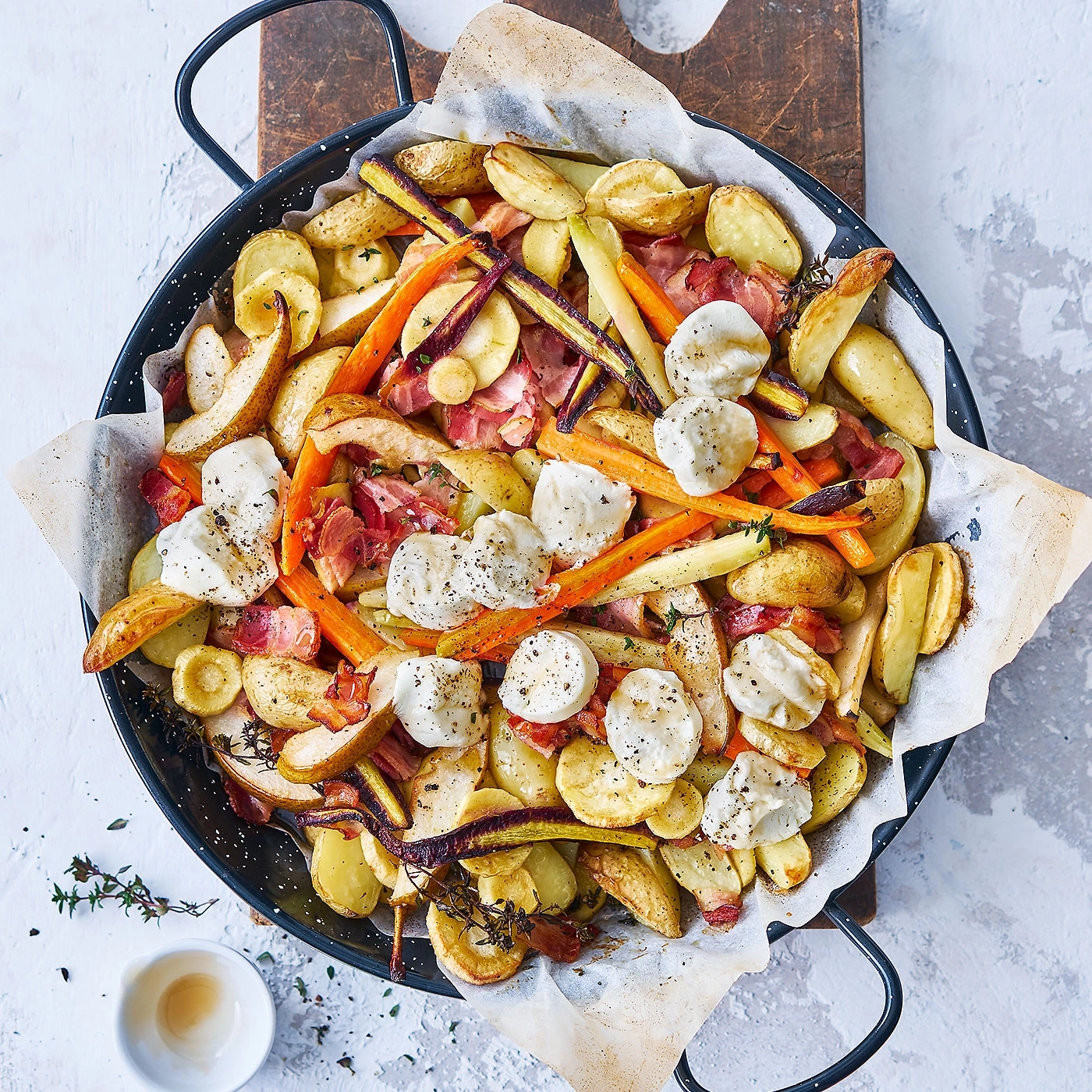 Légumes rôtis avec fromage et bacon dans une poêle sur une table