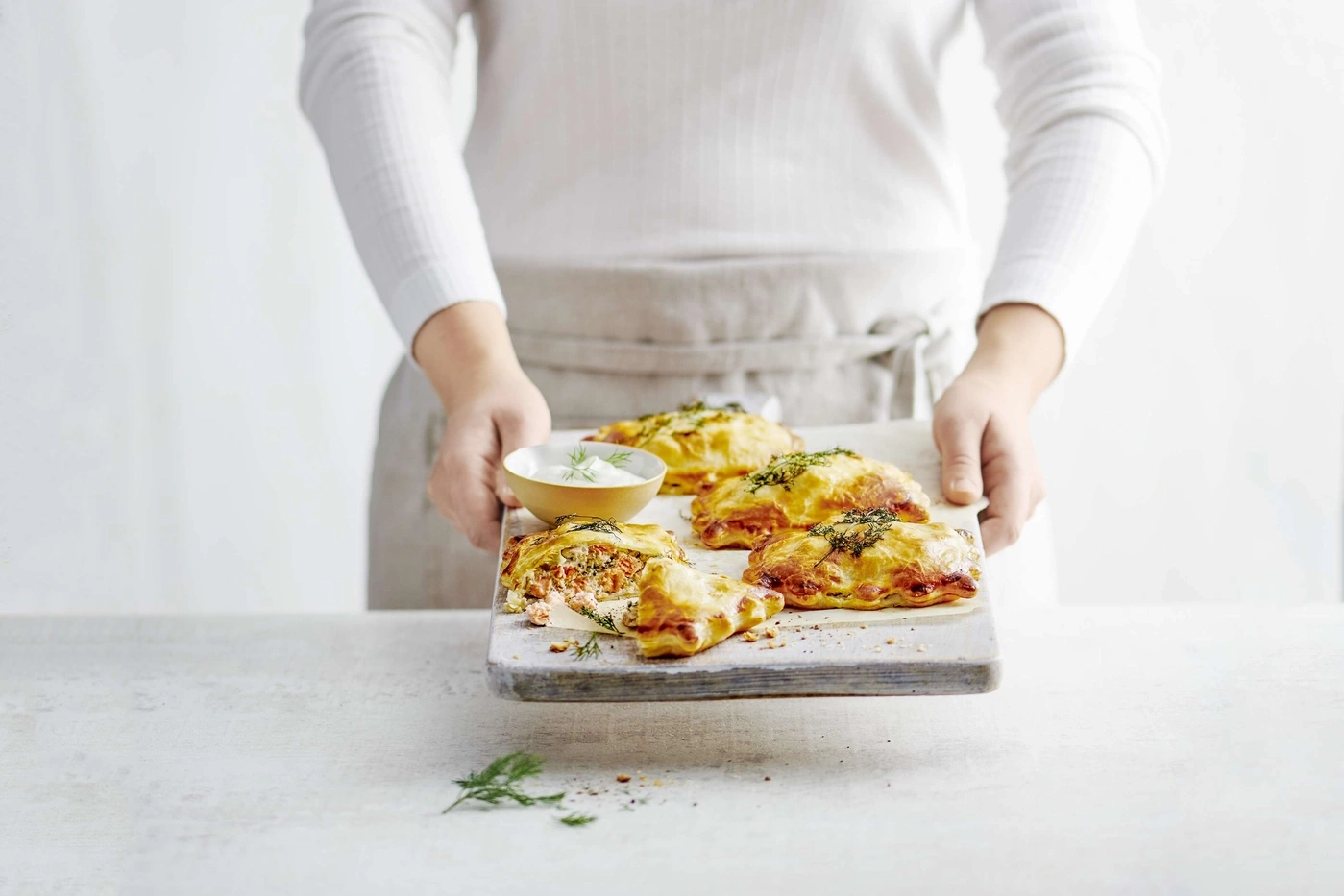 Person hält Tablett mit Gebäck und Dip, Nahaufnahme, helles Licht