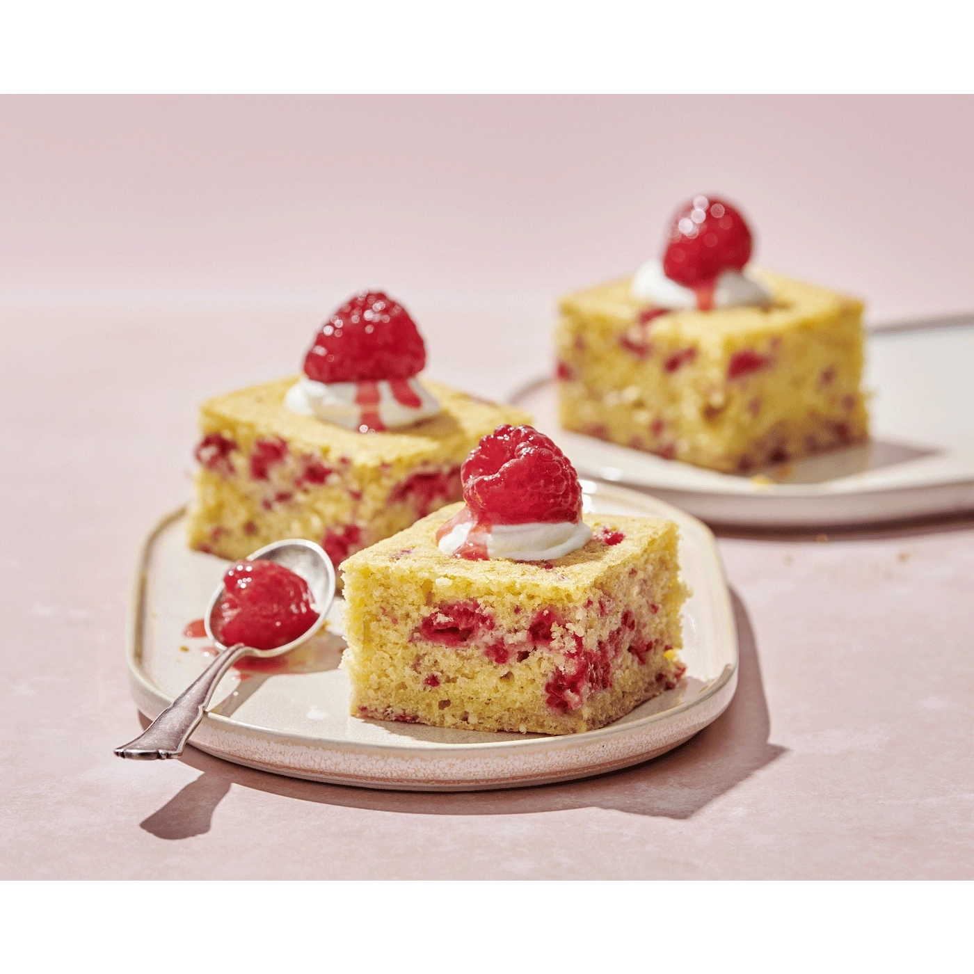 Himbeerkuchen mit Sahne und Himbeersauce auf einem Teller, Nahaufnahme