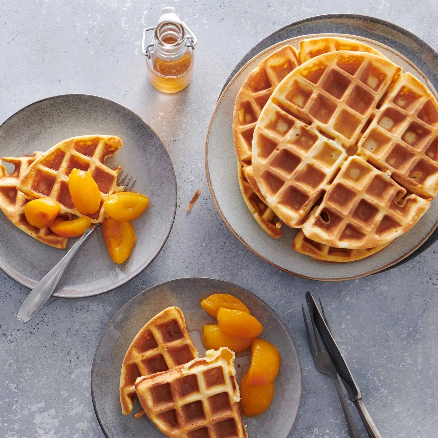 Waffeln mit Pfirsichen und Honig auf Tellern, Nahaufnahme, Frühstück
