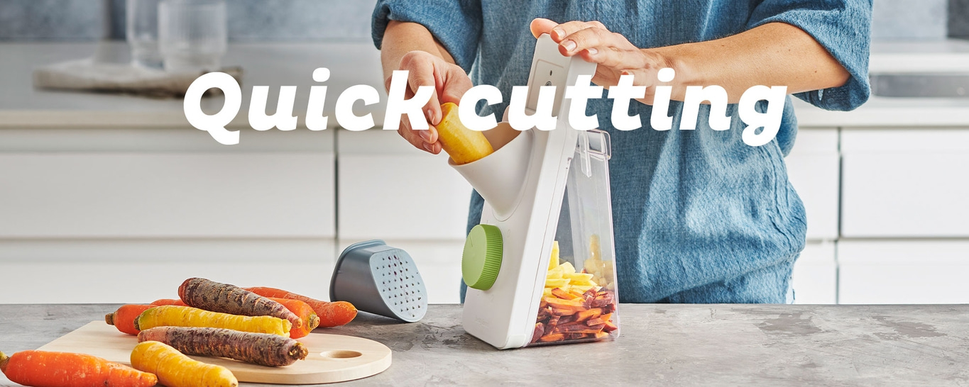 Coupe rapide de légumes avec un appareil de cuisine. Les carottes sont coupées rapidement.