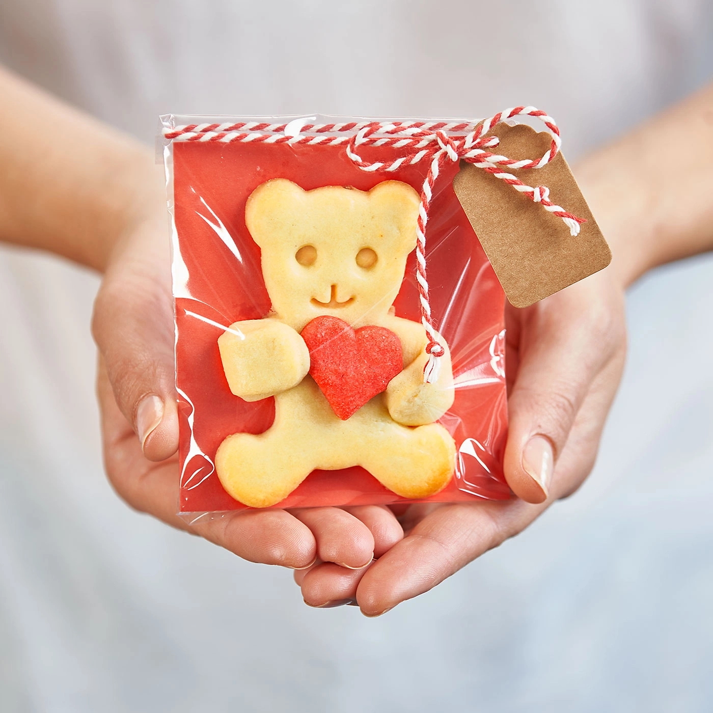 Biscuit en forme d'ours en peluche avec un cœur rouge dans un emballage cadeau