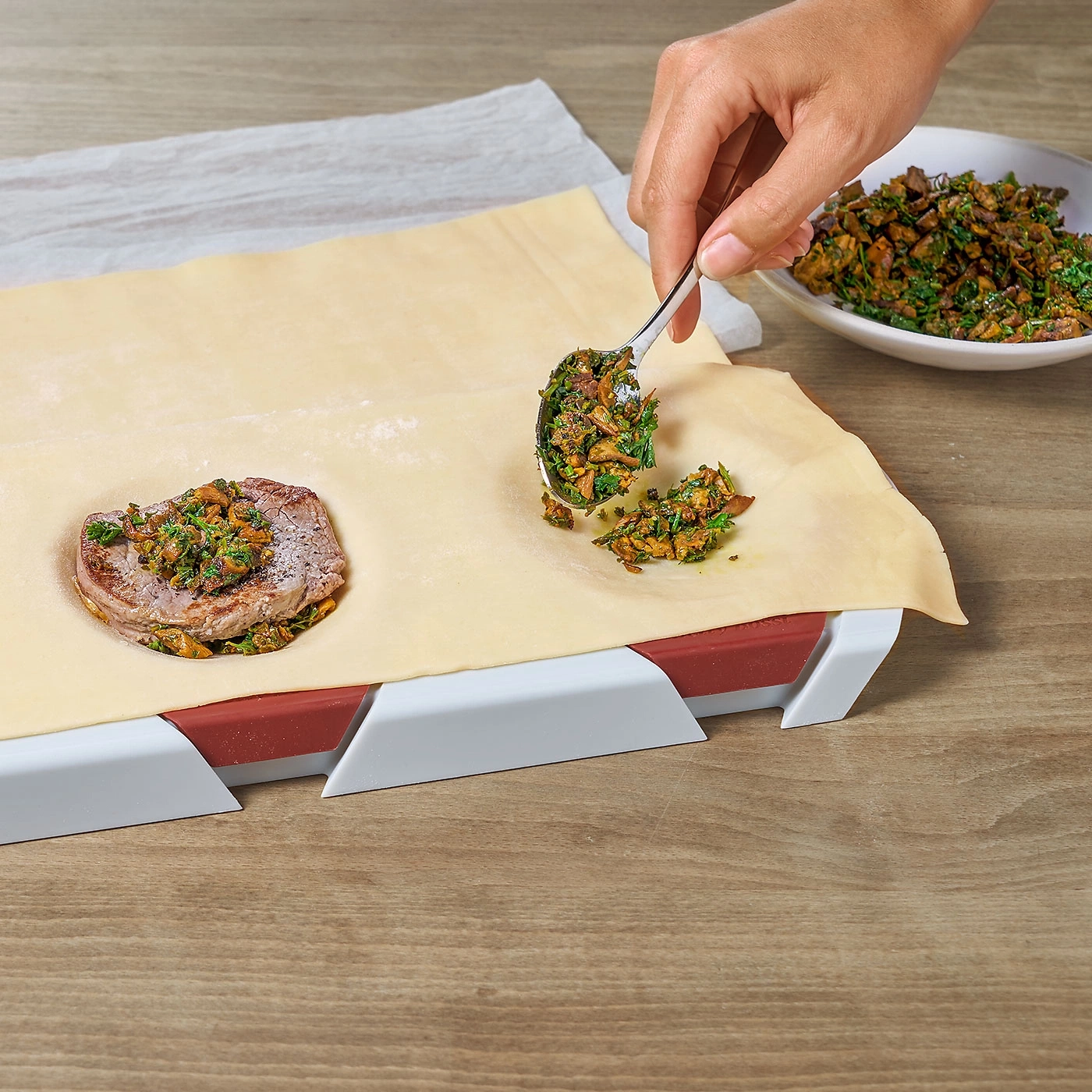 Personne prépare un plat, viande aux herbes sur une feuille de pâte
