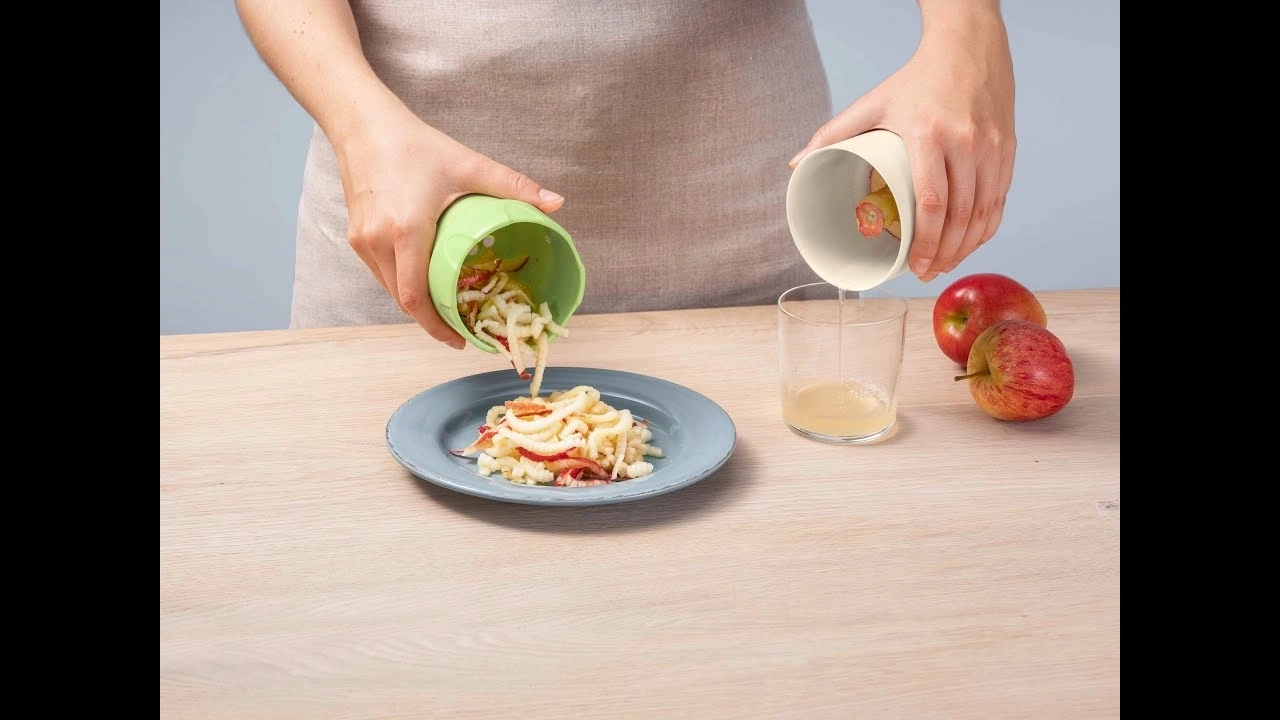 Person bereitet Apfelgericht zu, gießt Saft in ein Glas, serviert Apfelstücke.
