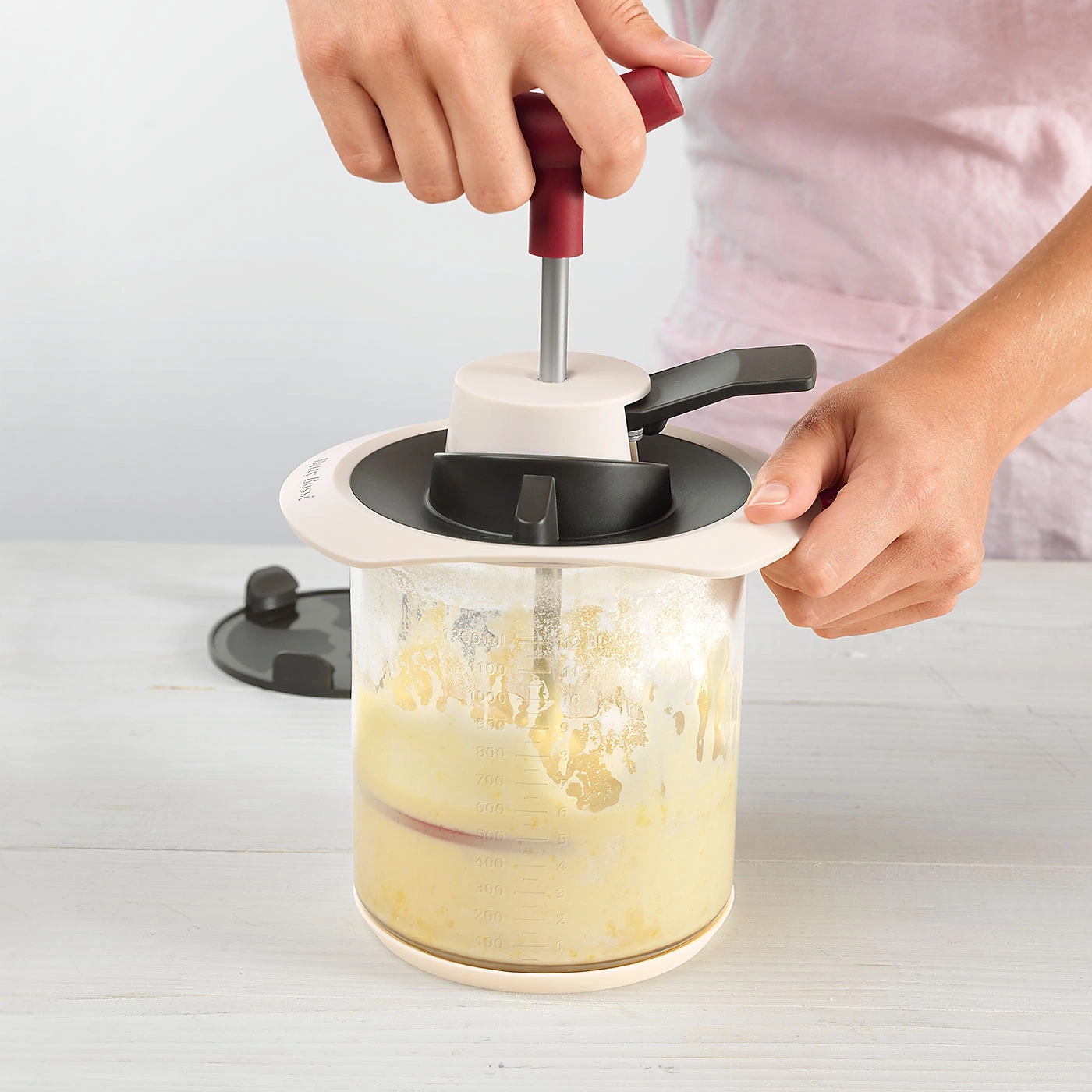 Person benutzt Küchengerät, um Zutaten zu verarbeiten. Kochen, Zubereitung, Küche.