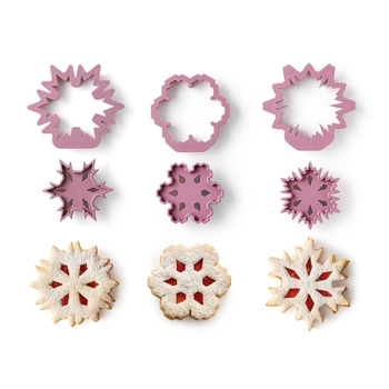 Emporte-pièces et biscuits en forme de flocons de neige sur fond blanc. Pâtisserie, Noël.