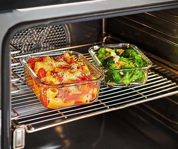 Ofen mit zwei Glasbehältern, gefüllt mit Pasta und Brokkoli.