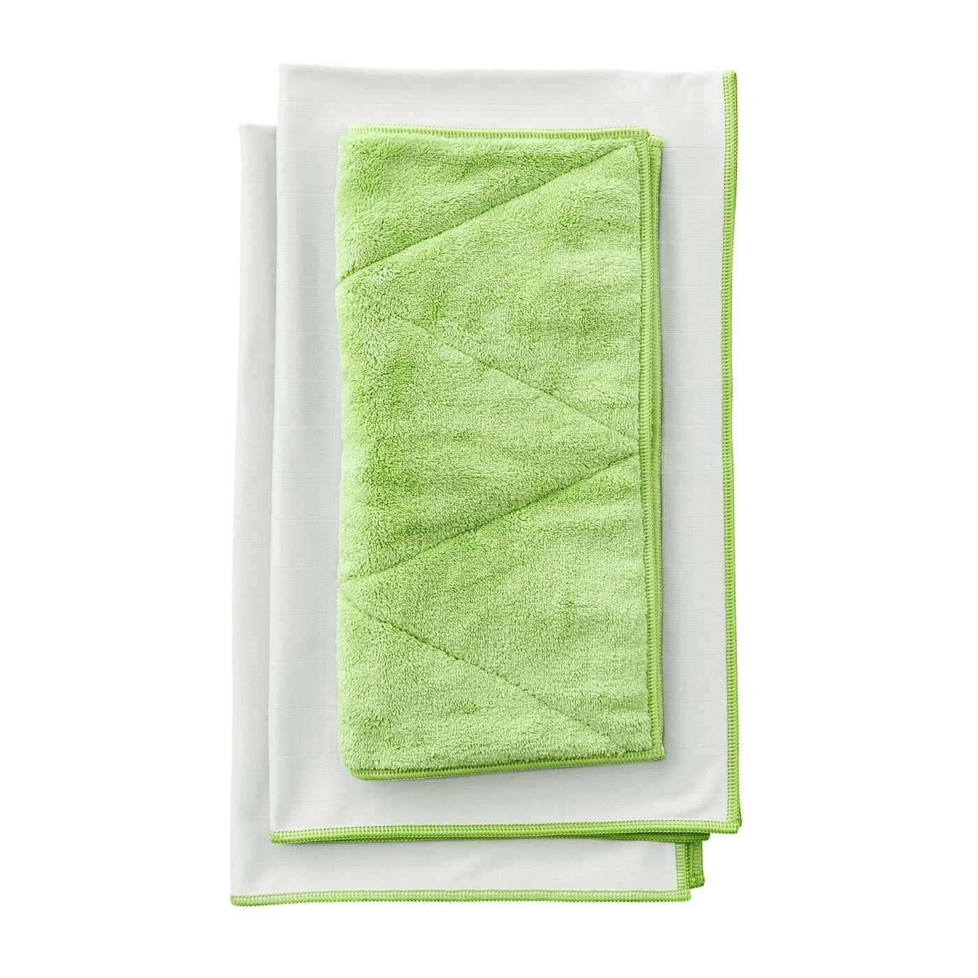 Des chiffons de nettoyage verts et blancs pliés et empilés sur fond blanc.