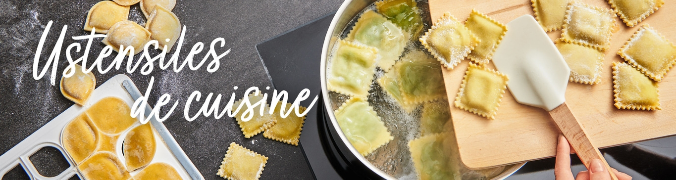 Raviolis dans l'eau bouillante avec ustensiles de cuisine sur planche de bois