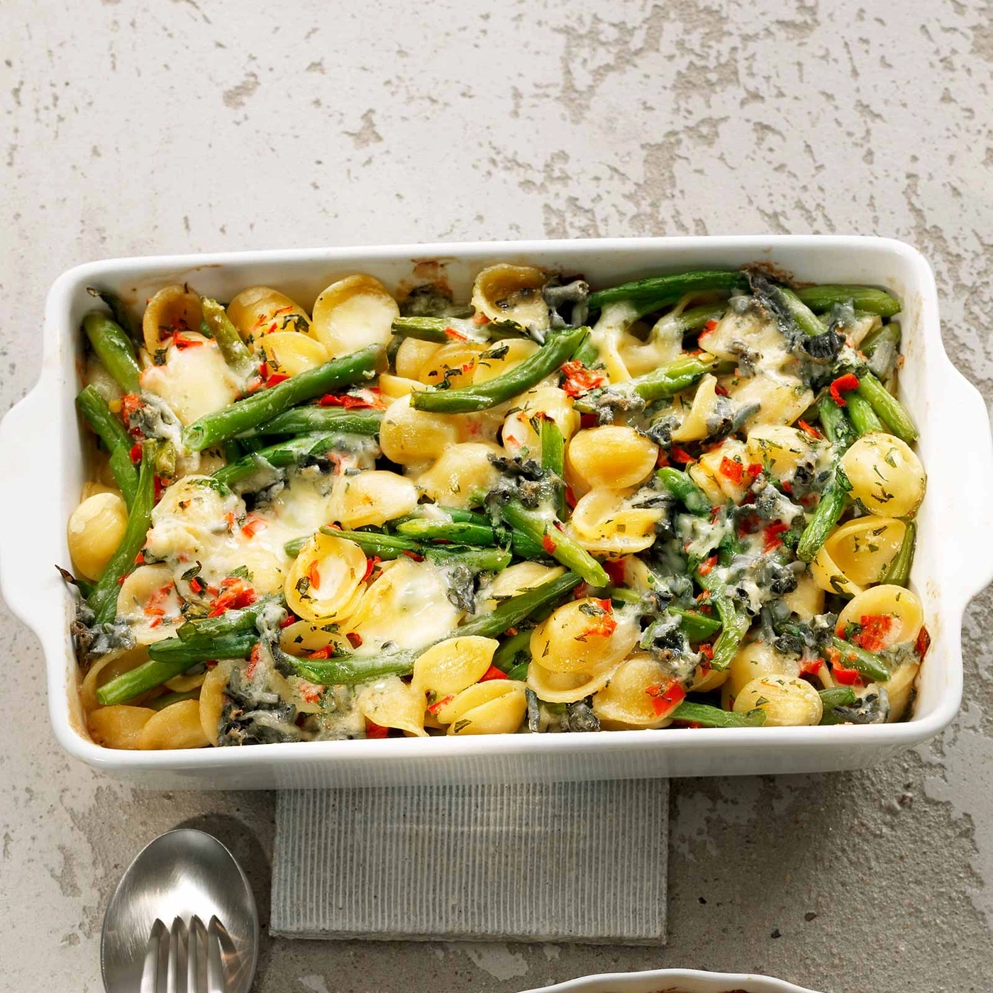 Orecchiette-Auflauf mit grünen Bohnen und Käse in einer weißen Auflaufform