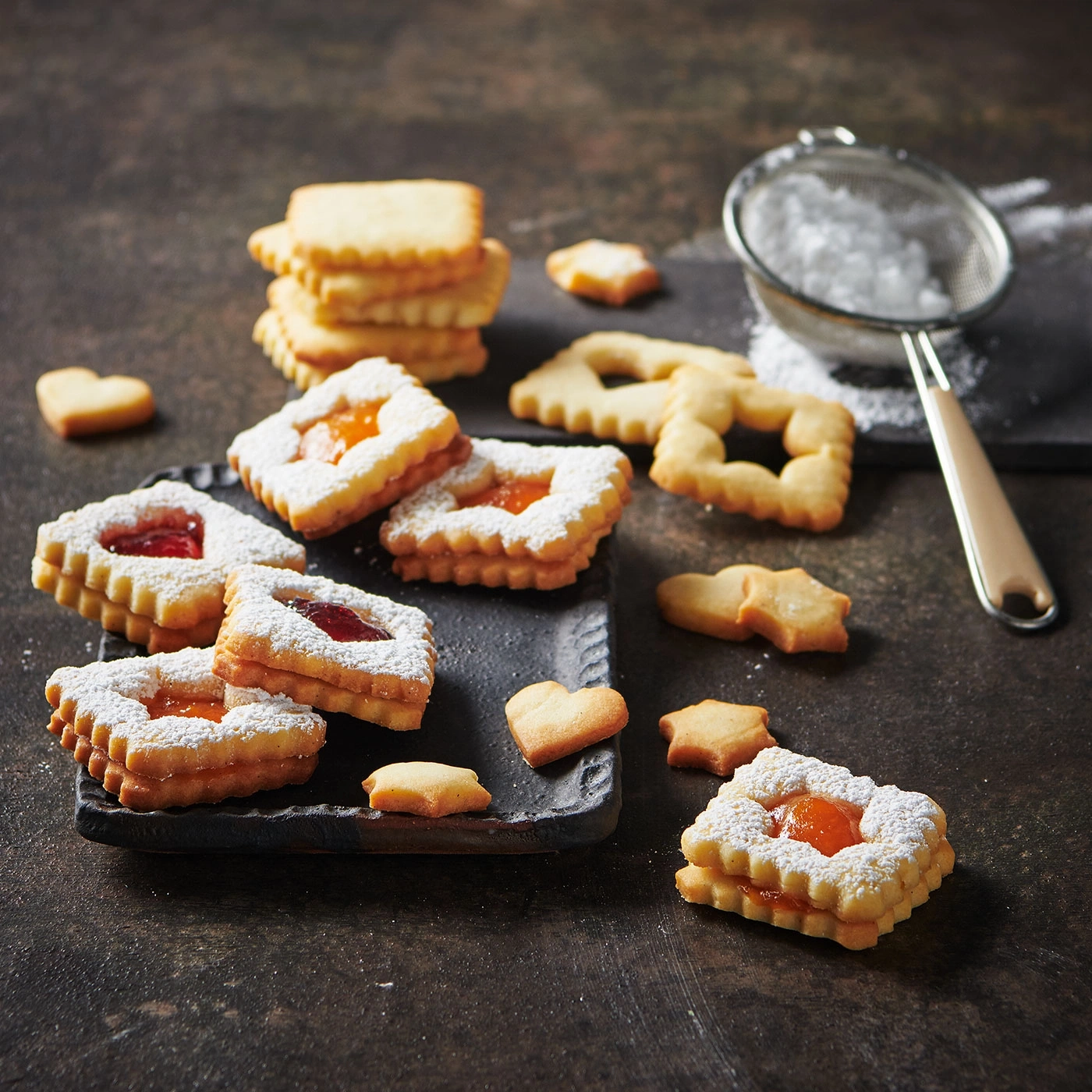 Biscuits à la confiture et au sucre glace sur fond sombre.