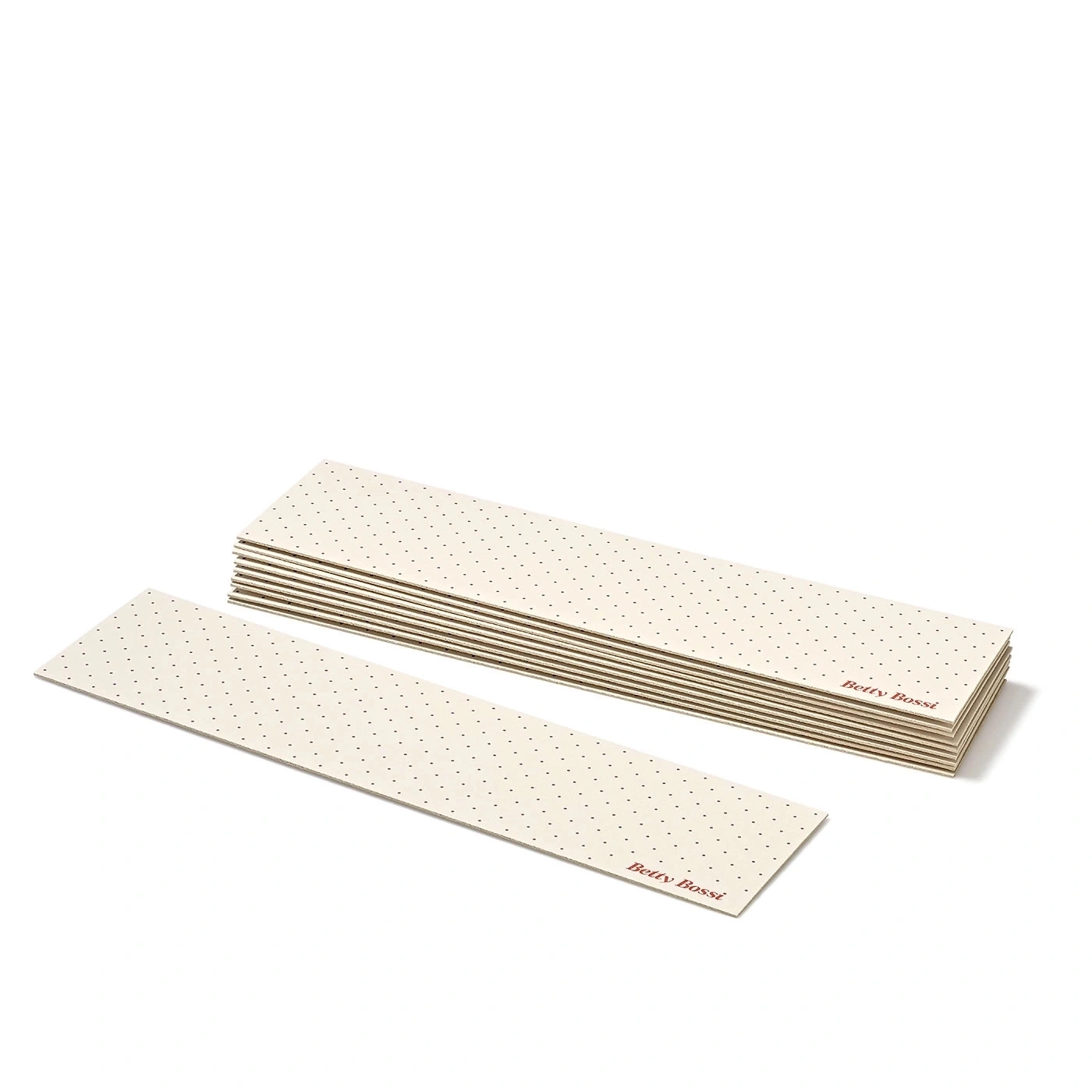 Pile de papiers rectangulaires perforés avec le logo 'Betty Bossi' sur fond blanc.