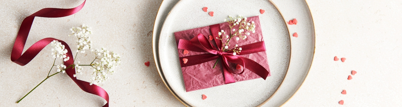 Cadeau sur une assiette avec ruban et fleurs, ambiance romantique
