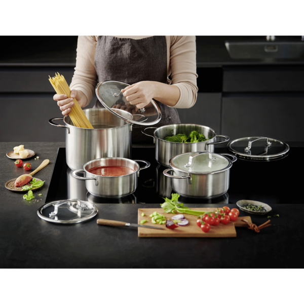 Cuisine avec pâtes, légumes et tomates. Ustensiles de cuisine sur la cuisinière.