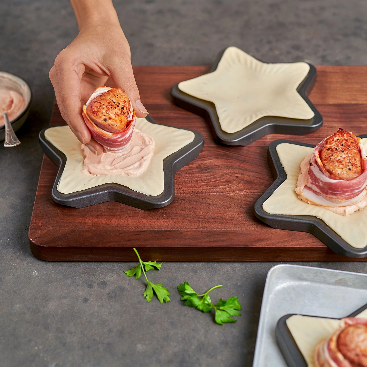 Personne prépare plat en forme d'étoile, viande enveloppée de bacon
