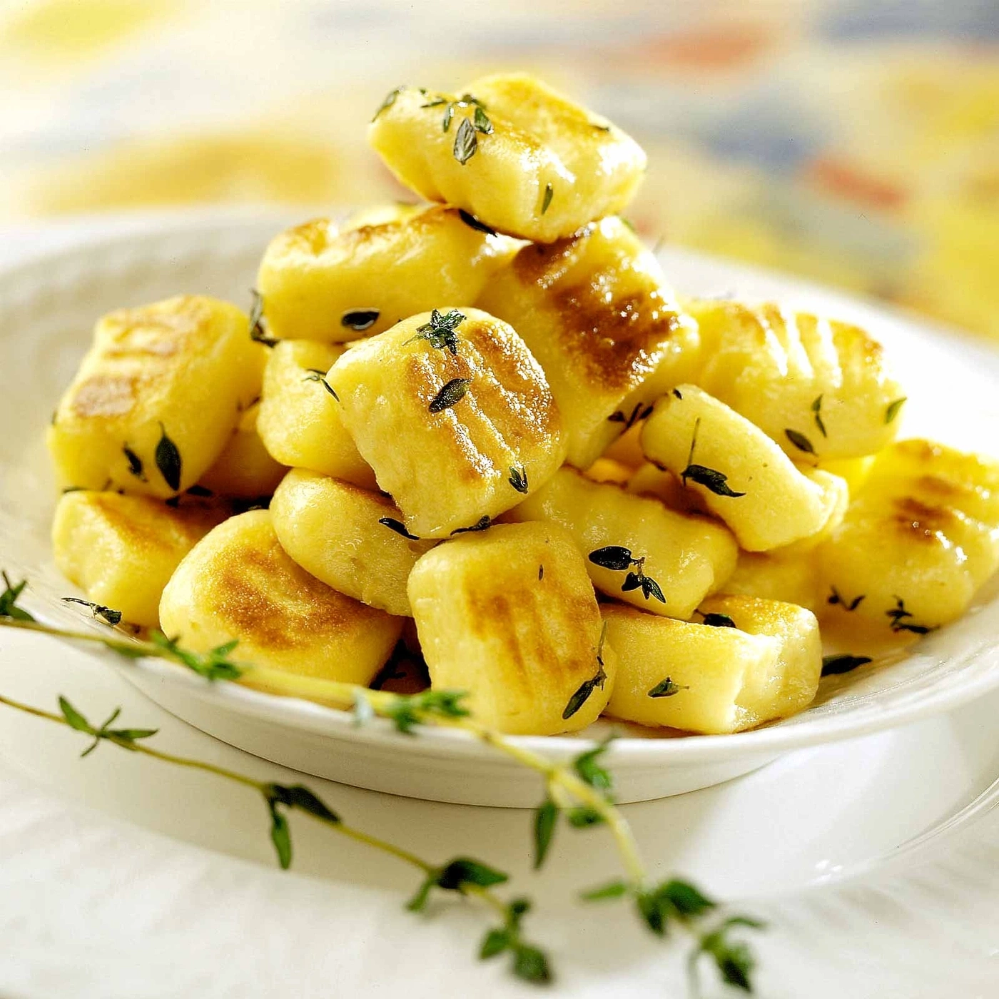 Gebratene Gnocchi mit Kräutern auf einem weißen Teller, Nahaufnahme