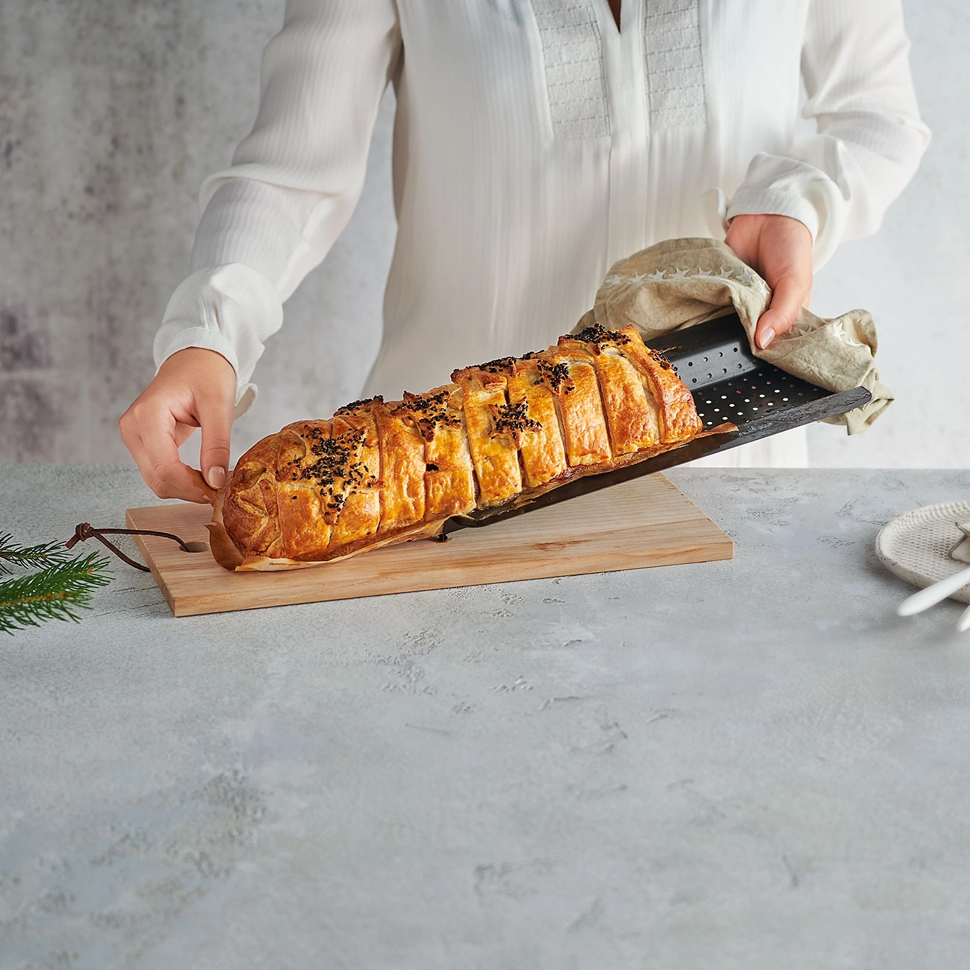 Person hält ein Gericht auf einem Holzbrett. Essen, Küche, Kochen, Mahlzeit, lecker.