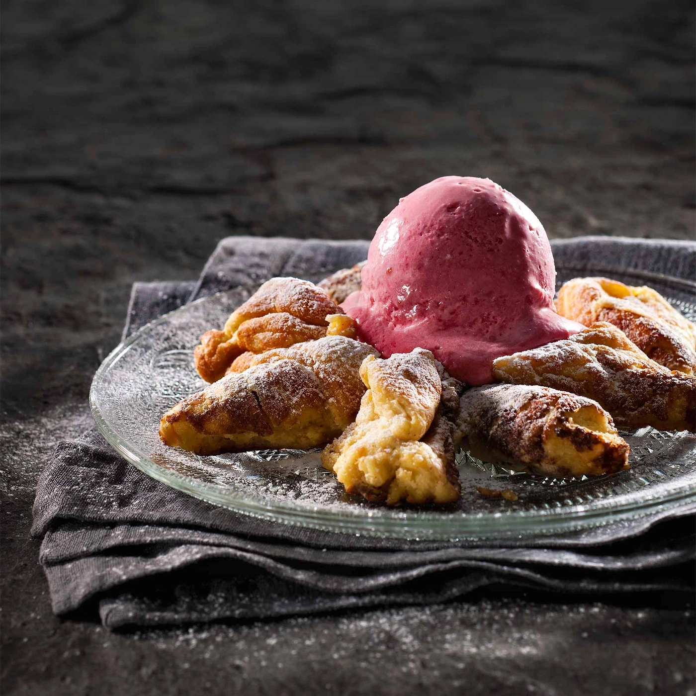 Dessert mit Eiscreme und Gebäck auf einem Teller, Puderzucker.