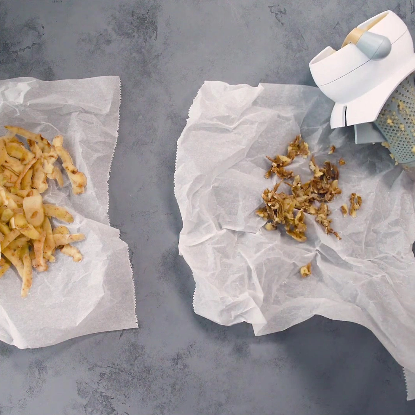 Deux papiers avec de la nourriture, à côté d'une râpe sur fond gris.