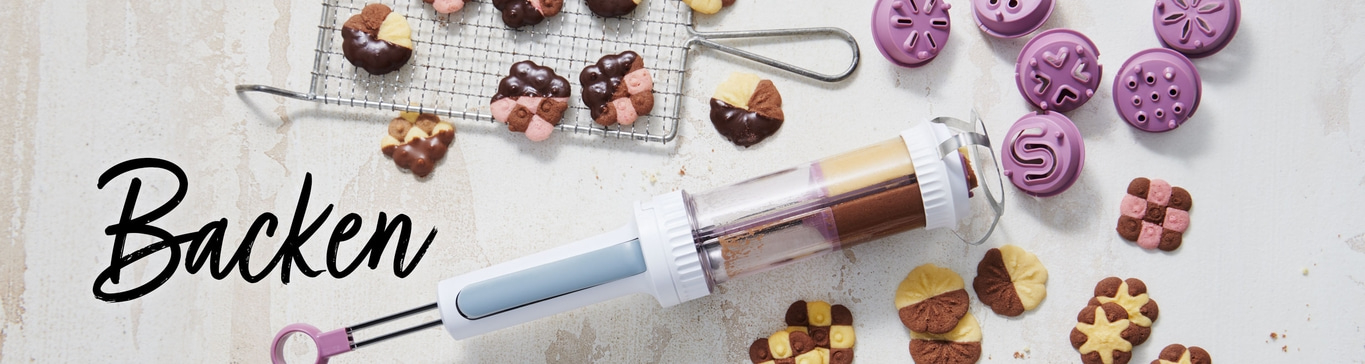 Backen-Szene mit Keksen, Spritzgebäck und Backutensilien auf hellem Hintergrund.