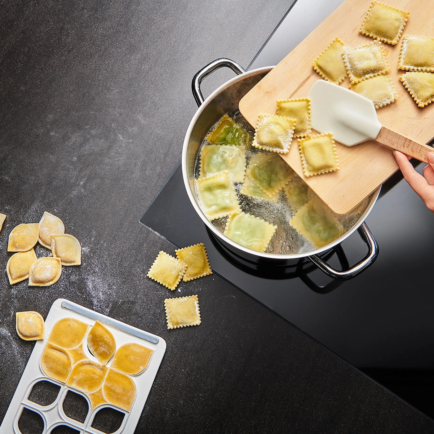 Raviolis en train de cuire dans une casserole. Pâtes sur une planche. Cuisine.