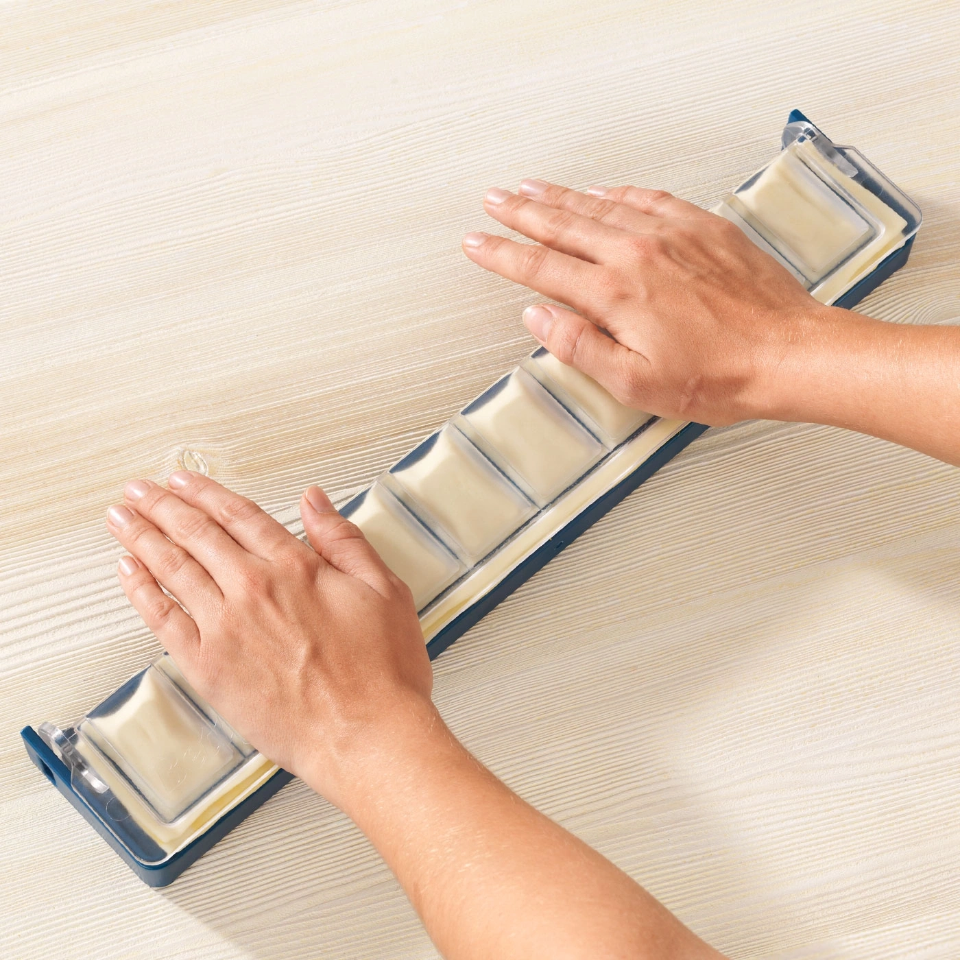 Mains sur un plateau avec des blocs carrés crème sur une surface en bois