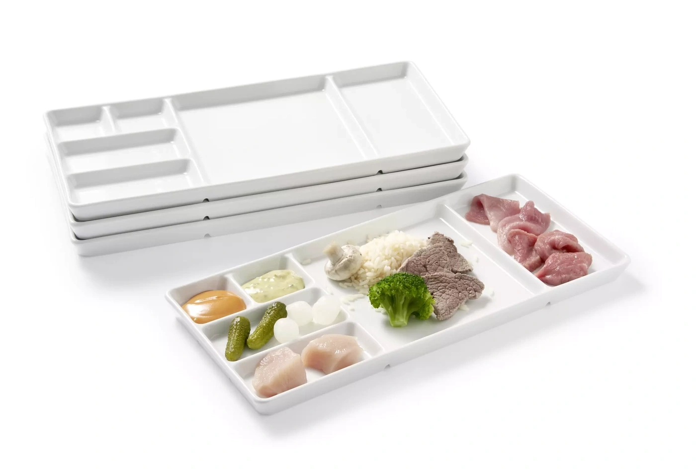Une assiette de service blanche à plusieurs compartiments, remplie de divers aliments.