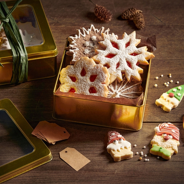 Betty Bossi Guetzli-Ausstecher Wichtel 6-7 cm - 3er-Set Weihnachtsplätzchen in einer Dose auf einem Holztisch, festlich dekoriert.