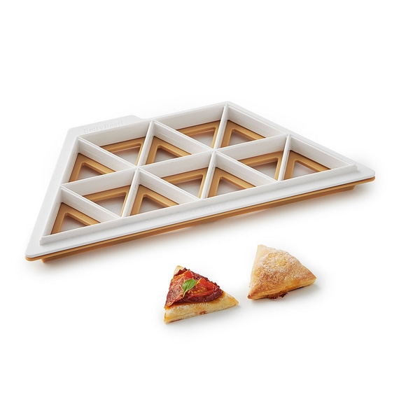 Coupe-pizza avec deux morceaux de pizza. Accessoires blancs et marron. Betty Bossi.