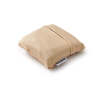 Ein beige Kissen von Betty Bossi mit kleinem Label auf der Seite