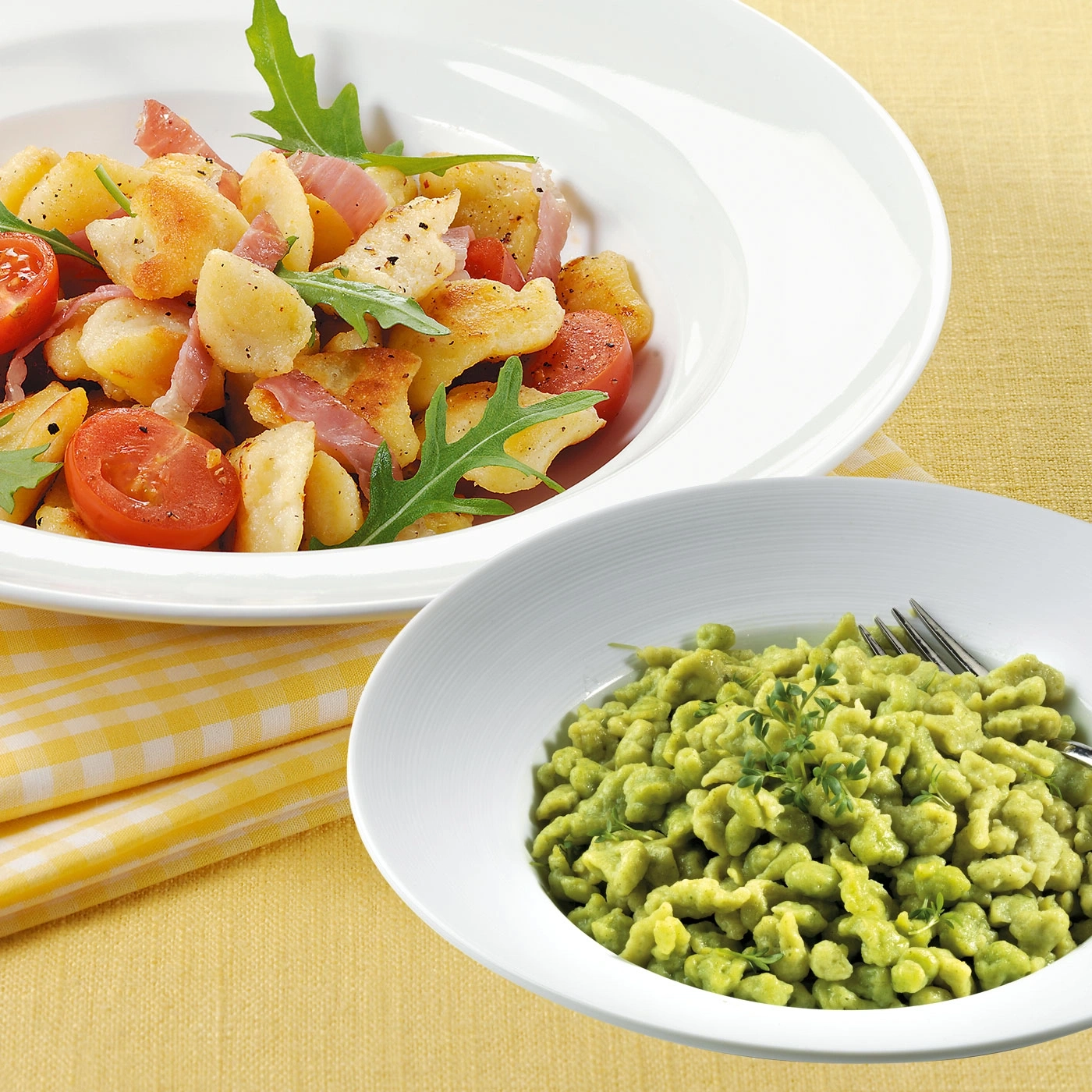 Zwei Schüsseln mit Essen, eine mit Kartoffeln, die andere mit Nudeln.