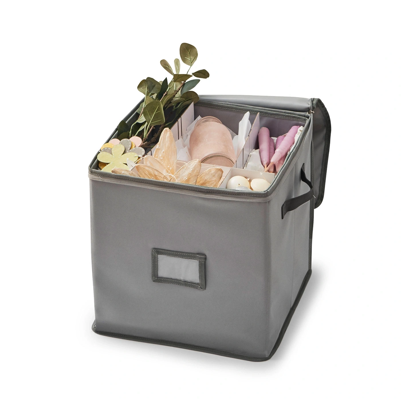 Boîte de rangement grise ouverte avec diverses décorations, poignées visibles.