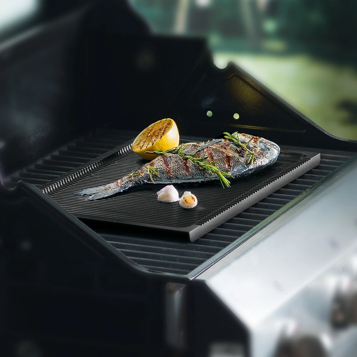 Gegrillter Fisch mit Zitrone und Knoblauch auf einem Grillrost