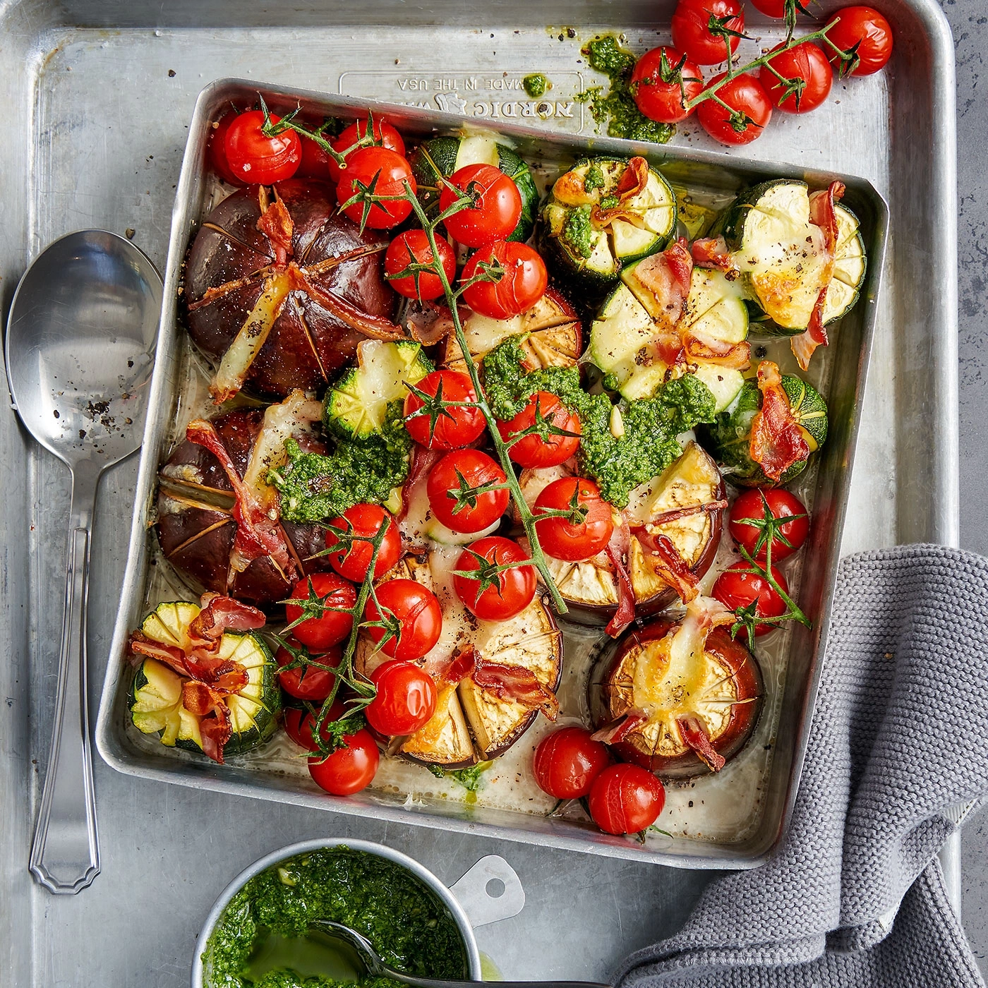 Gebratene Tomaten, Zucchini, Speck und Pesto auf einem Tablett
