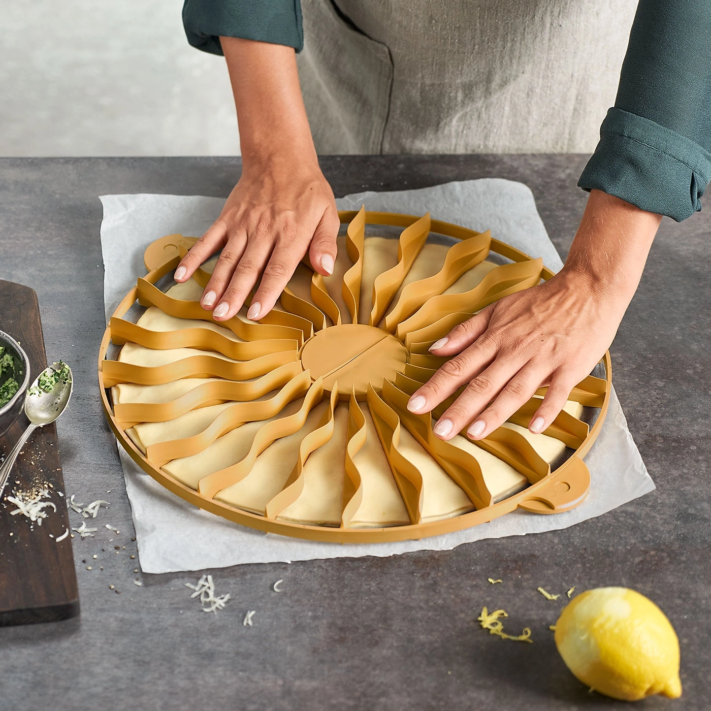 Une personne façonne de la pâte avec un outil spécial. Outil jaune, citron, mains.