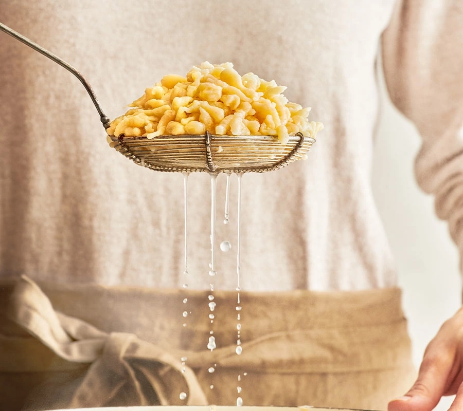 Spätzle werden aus einem Sieb abgetropft, Kochvorgang, Küche, Essen, Nudeln