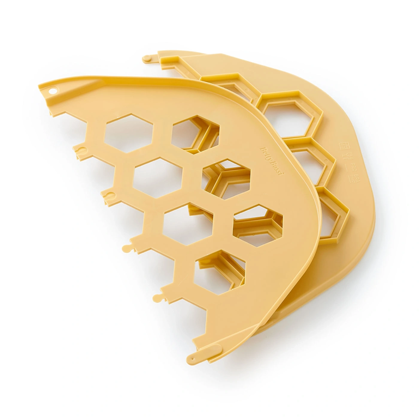Accessoires de cuisine jaunes en forme de nid d'abeille sur fond blanc.