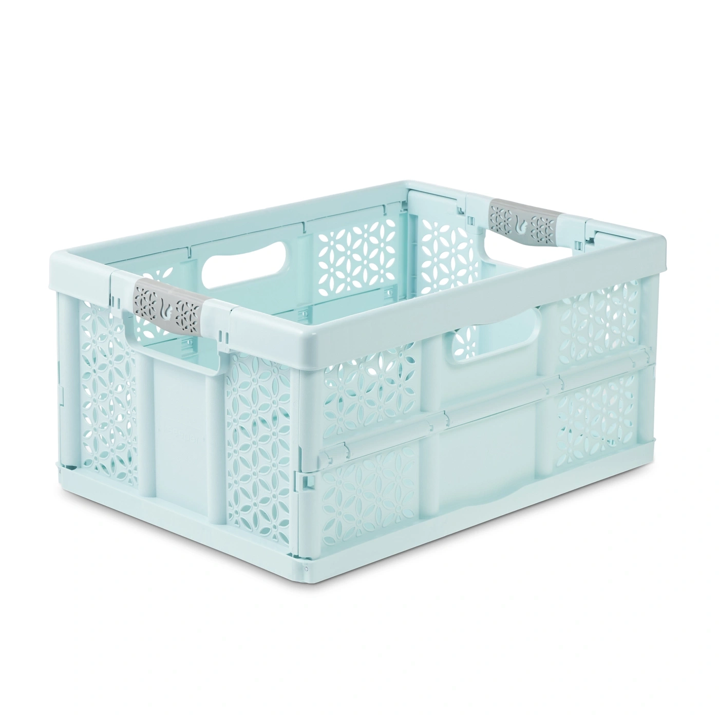 Un panier pliable turquoise à motif floral avec poignées grises sur fond blanc.