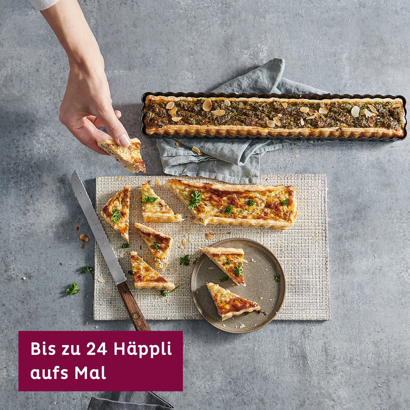 Quiche mit Mandeln, serviert mit Messer und Teller, auf grauem Hintergrund.
