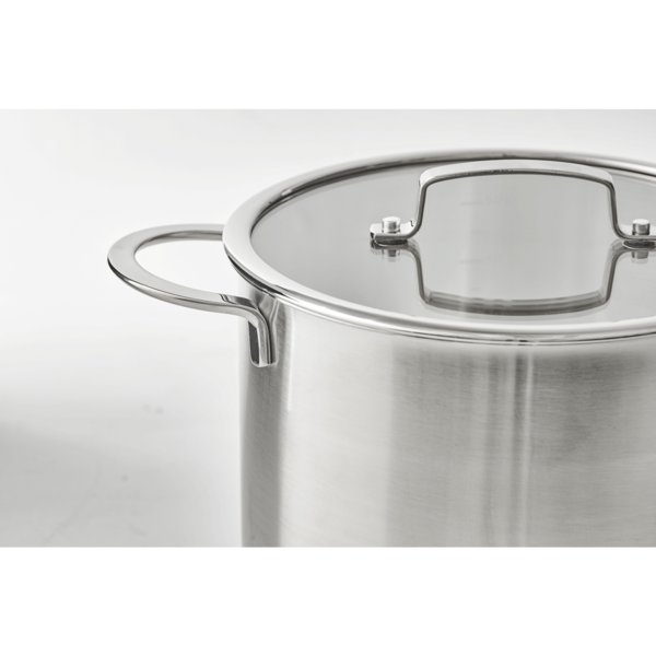 Gros plan sur une casserole en acier inoxydable avec couvercle en verre et poignées