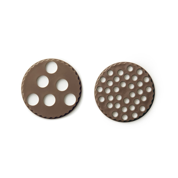 Deux tamis ronds bruns avec des trous sur fond blanc. Vue rapprochée.