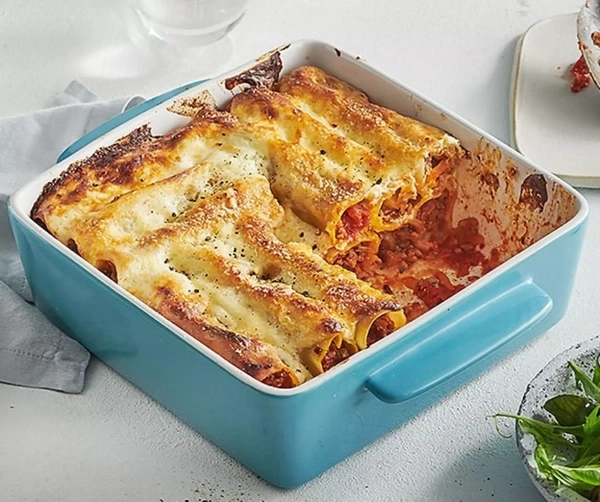 Gefüllte Cannelloni in einer blauen Auflaufform mit Käse überbacken