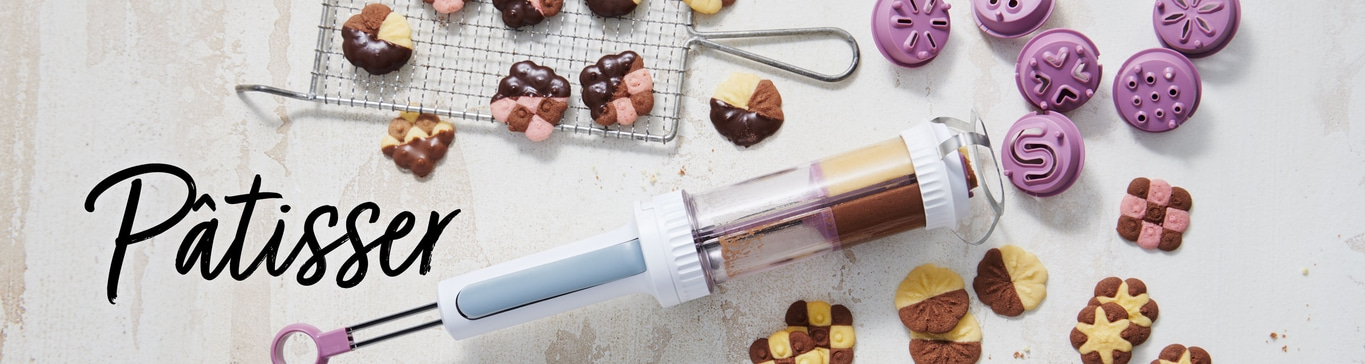 Biscuits, ustensiles de pâtisserie et décorations sur fond clair. Inscription Patissier.
