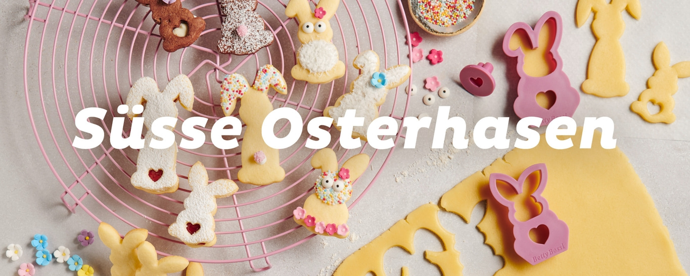 Süße Osterhasen Kekse auf einem rosa Gitter mit Ausstechern