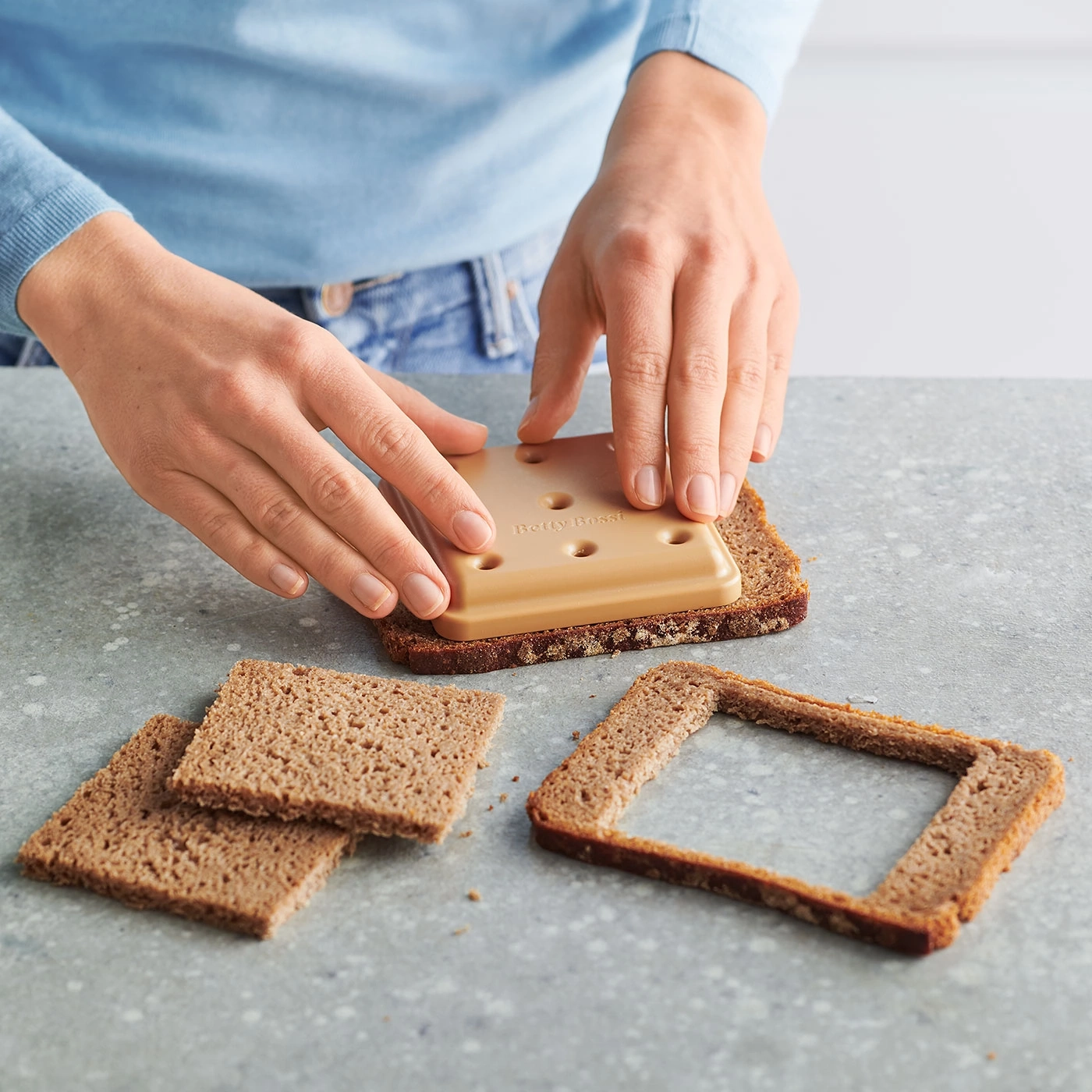 Person schneidet Brot mit einem speziellen Werkzeug, um eine Form zu erzeugen.