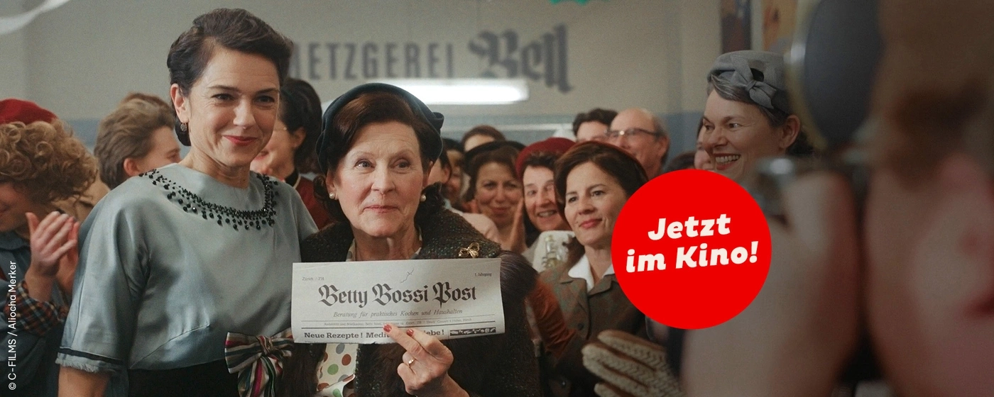 Gruppe von Frauen bei einer Veranstaltung, die eine Zeitung halten.