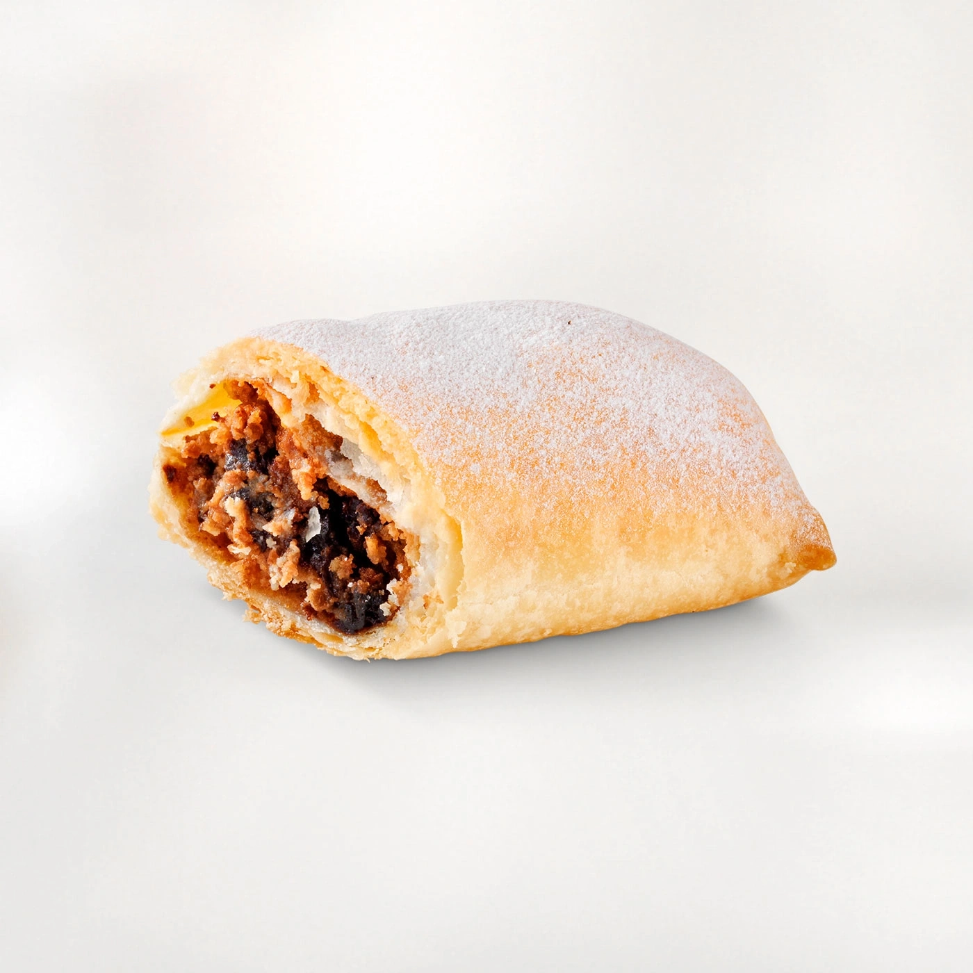 Gros plan d'une pâtisserie saupoudrée de sucre glace, coupée pour révéler la garniture.