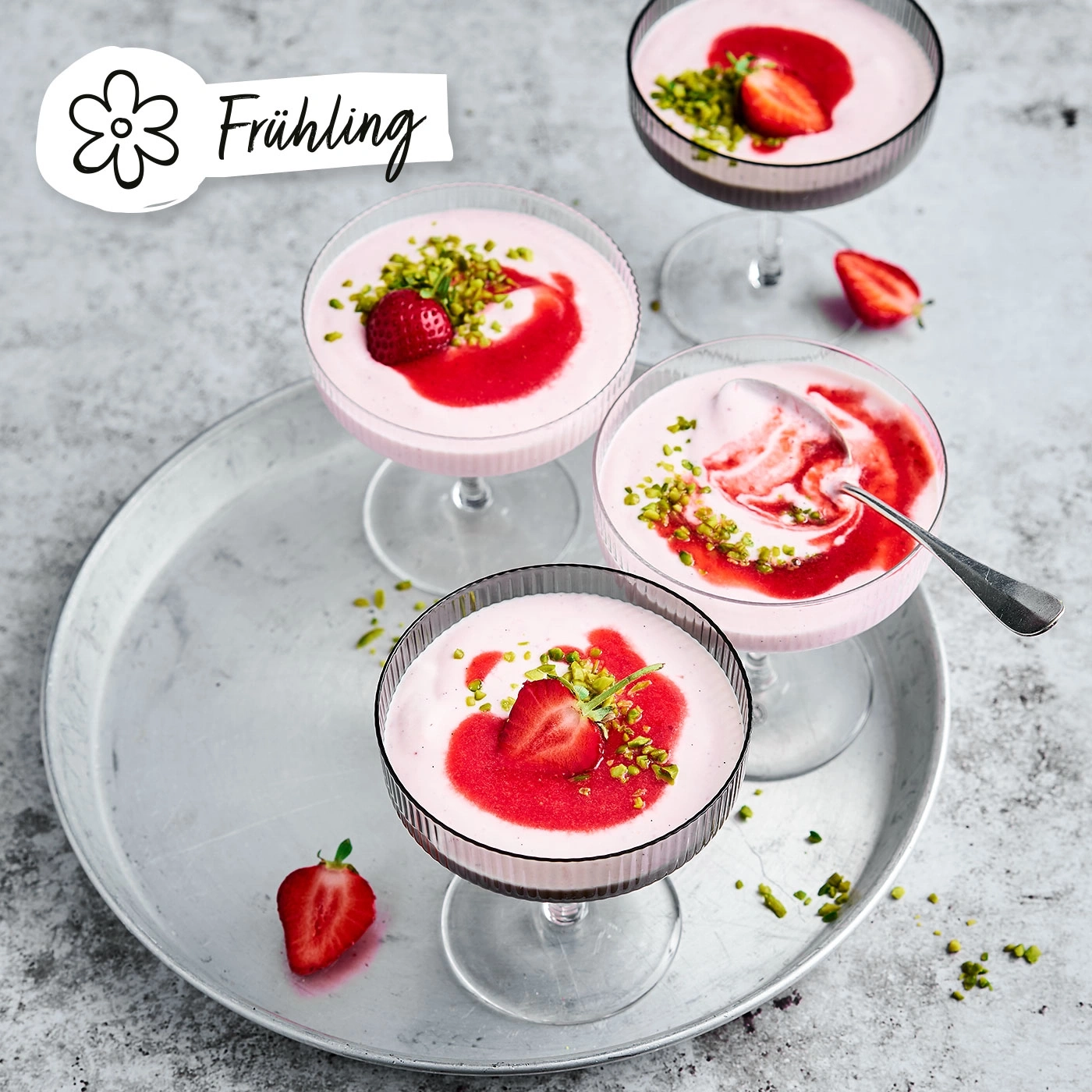Erdbeer-Desserts in Gläsern mit Pistazien auf einem Tablett, Frühling.