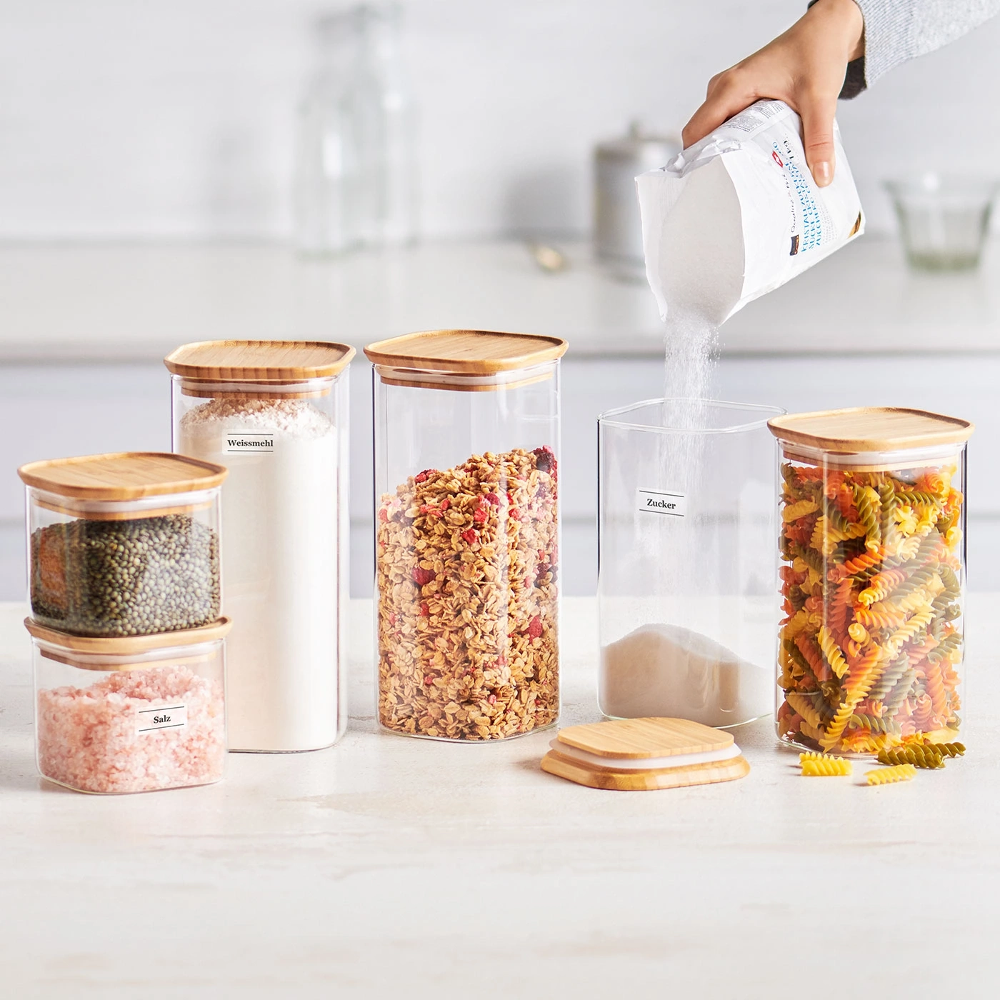Gläser mit Lebensmitteln, darunter Zucker, Mehl, Nudeln und Müsli.
