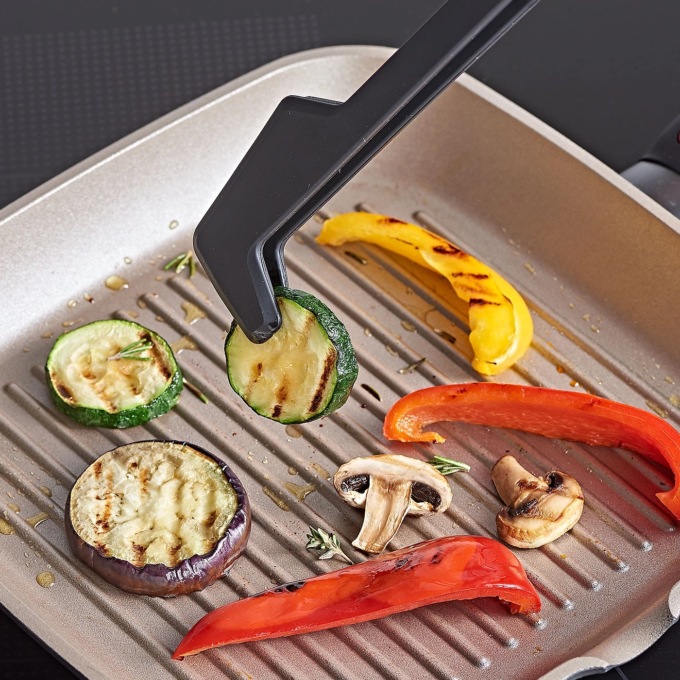 Légumes grillés dans une poêle. Courgettes, poivrons, aubergines, champignons et pince.